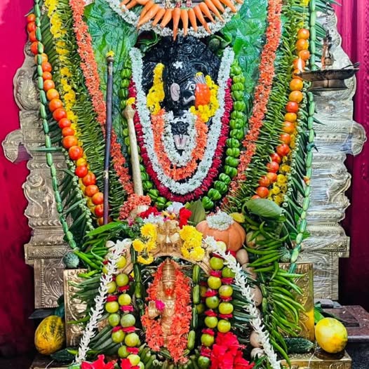 Sri Muradi Anjaneya Swamy deity adorned with flowers and fruits